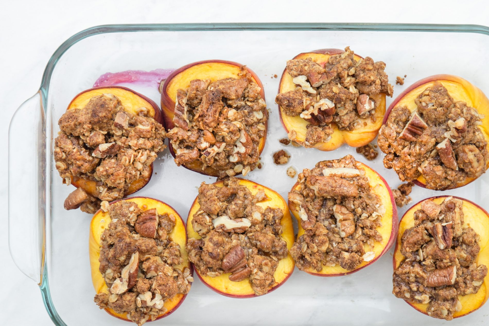 multiple personal pecan peach crumbles arranged in a pan